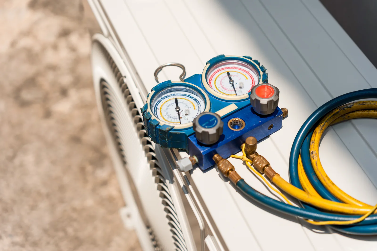 HVAC manifold gauge set connected to an outdoor AC unit, the pressure readings a technician uses to confirm a compressor diagnosis